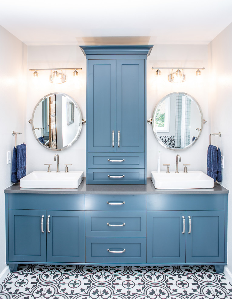 Inspiration for a large transitional master bathroom in Denver with shaker cabinets, blue cabinets, a freestanding tub, a corner shower, a one-piece toilet, white tile, ceramic tile, grey walls, ceramic floors, a vessel sink, engineered quartz benchtops, multi-coloured floor, a hinged shower door and grey benchtops.