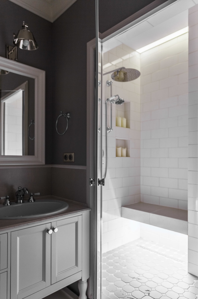 Mid-sized contemporary 3/4 bathroom in Moscow with an alcove shower, raised-panel cabinets, white cabinets, an alcove tub, a wall-mount toilet, white tile, subway tile, white walls, porcelain floors, a drop-in sink, solid surface benchtops, beige floor, a hinged shower door and grey benchtops.
