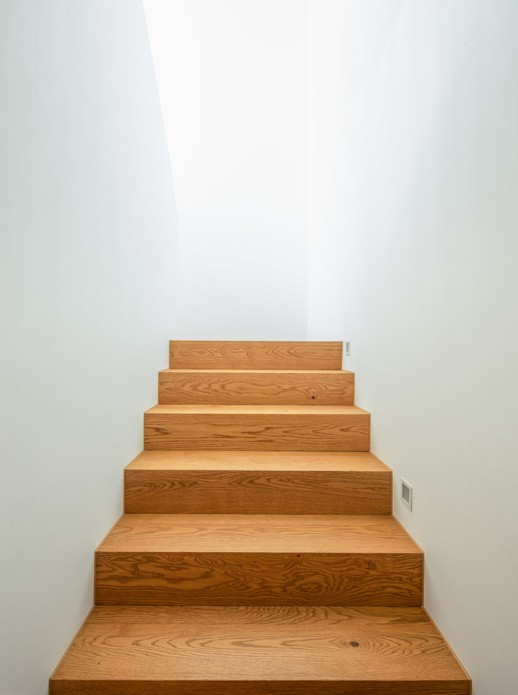 This is an example of a small modern wood straight staircase in Stuttgart with wood risers.