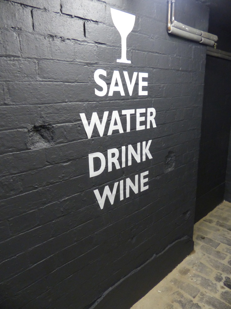 Wine cellar - eclectic brick floor wine cellar idea in London