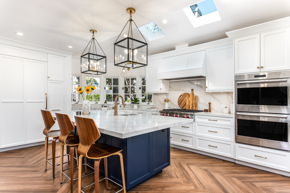 Eat-in kitchen - mid-sized transitional single-wall ceramic tile and brown floor eat-in kitchen idea in Los Angeles with a double-bowl sink, shaker cabinets, white cabinets, quartz countertops, white backsplash, quartz backsplash, stainless steel appliances, an island and white countertops
