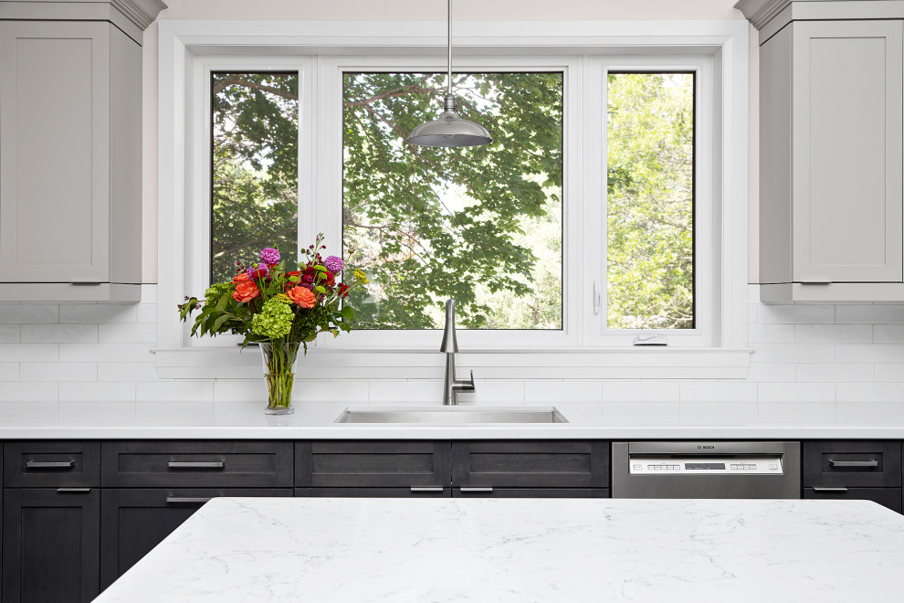Inspiration for a transitional u-shaped eat-in kitchen remodel in Toronto with an undermount sink, shaker cabinets, gray cabinets, quartz countertops, white backsplash, subway tile backsplash, stainless steel appliances, an island and white countertops