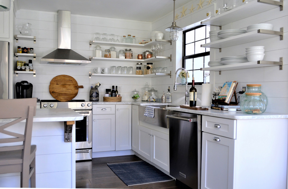 Inspiration for a small beach style l-shaped open plan kitchen in Charleston with a farmhouse sink, flat-panel cabinets, white cabinets, quartz benchtops, white splashback, timber splashback, stainless steel appliances, dark hardwood floors, with island and brown floor.