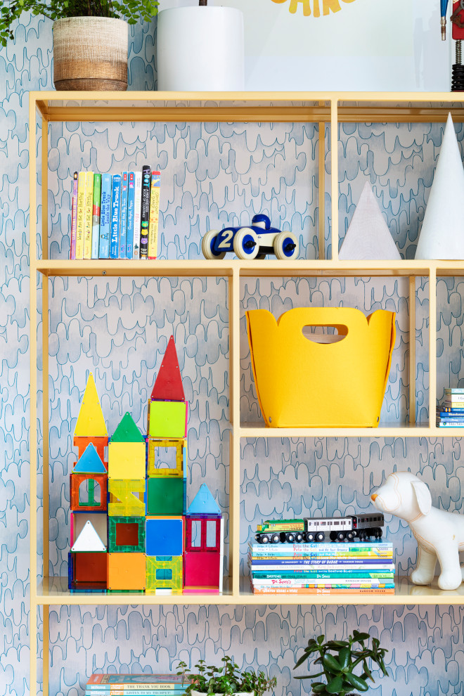 На фото: нейтральная детская среднего размера в современном стиле с спальным местом, синими стенами, ковровым покрытием, разноцветным полом, балками на потолке и обоями на стенах для ребенка от 4 до 10 лет с