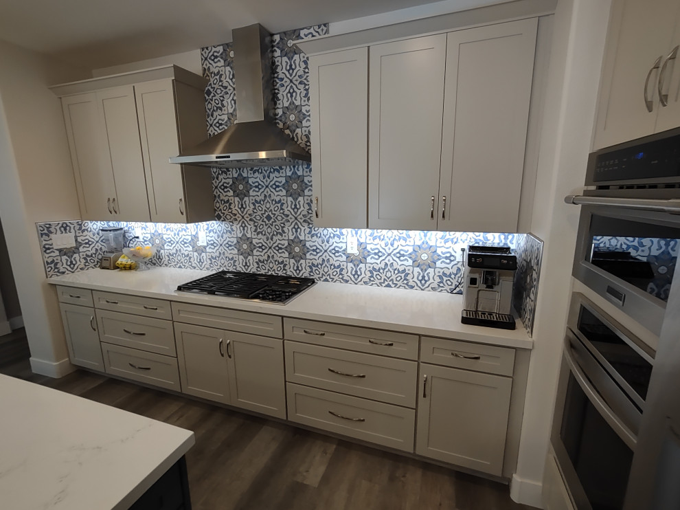 Kitchen - large transitional l-shaped kitchen idea in Las Vegas with shaker cabinets, white cabinets, quartz countertops, an island and white countertops
