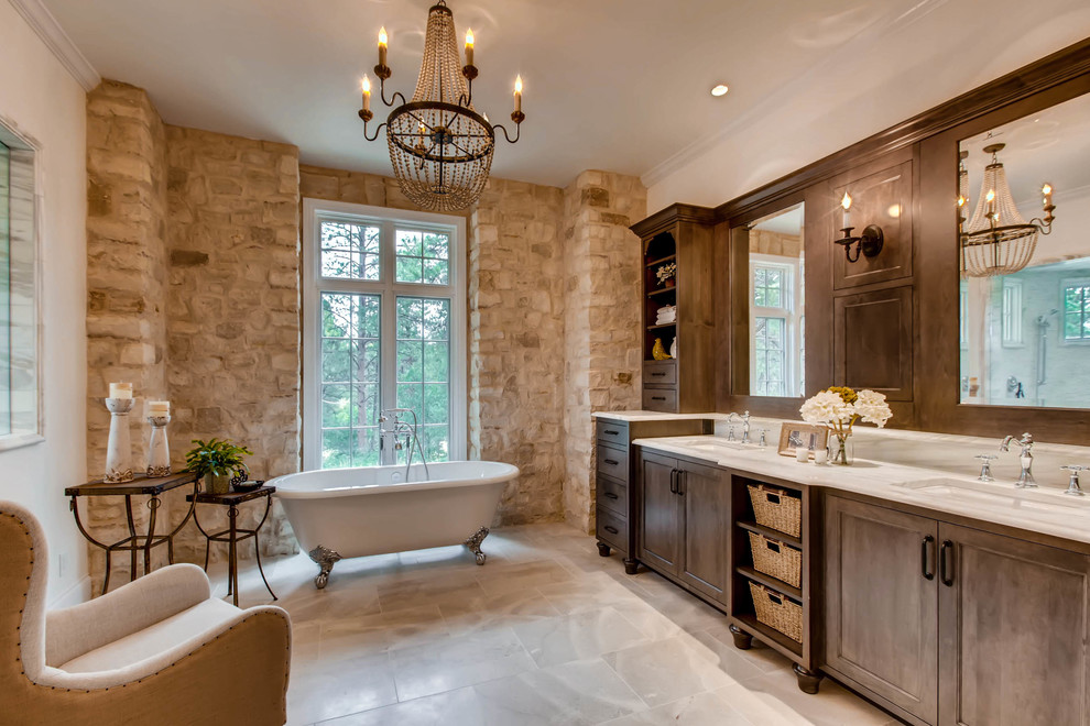 This is an example of a mediterranean master bathroom in Denver with shaker cabinets, brown cabinets, a claw-foot tub, an undermount sink and white floor.