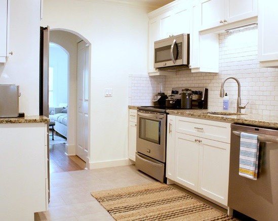 Small transitional galley eat-in kitchen in Tampa with an undermount sink, shaker cabinets, white cabinets, granite benchtops, white splashback, subway tile splashback, stainless steel appliances, ceramic floors and no island.