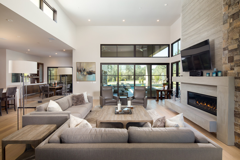 This is an example of a mid-sized contemporary formal open concept living room in Sacramento with white walls, light hardwood floors, a wall-mounted tv, beige floor, a ribbon fireplace and a concrete fireplace surround.