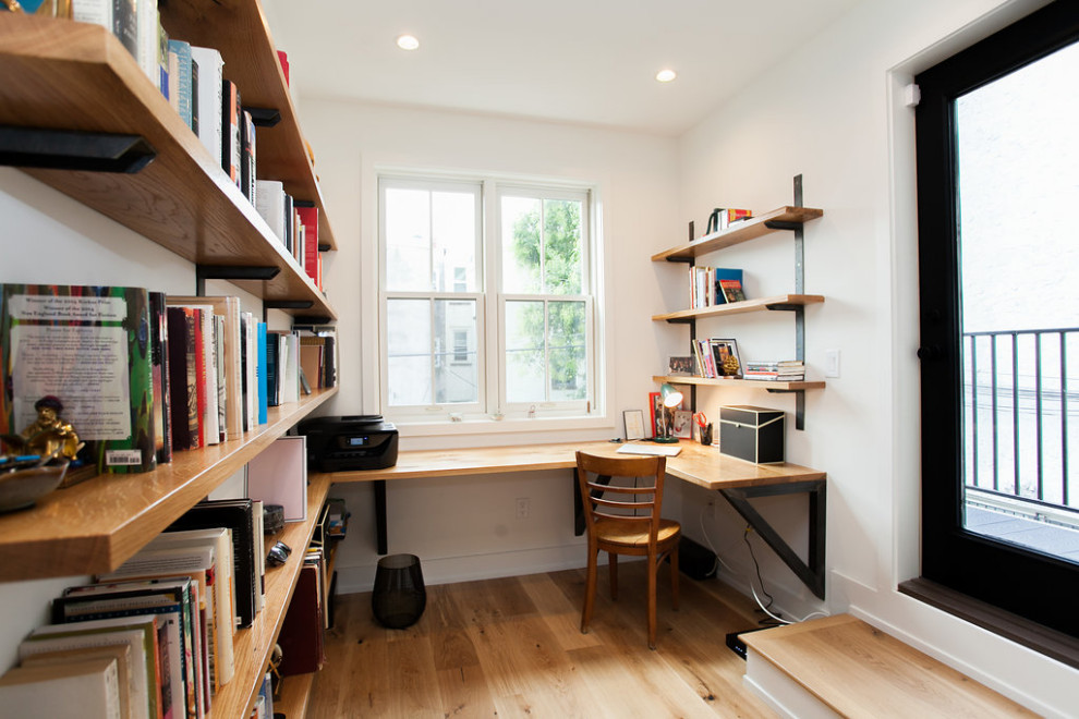 Idee per uno studio design con parquet chiaro, pavimento beige, libreria, pareti bianche e scrivania incassata