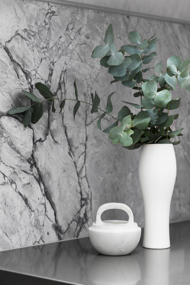 Design ideas for a large contemporary galley kitchen pantry in Melbourne with an undermount sink, shaker cabinets, white cabinets, quartz benchtops, grey splashback, stone slab splashback, stainless steel appliances, light hardwood floors, with island and grey benchtop.