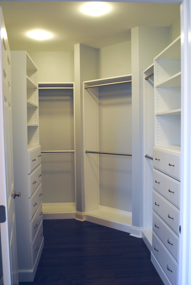 This is an example of a mid-sized transitional gender-neutral walk-in wardrobe in DC Metro with flat-panel cabinets, white cabinets and dark hardwood floors.