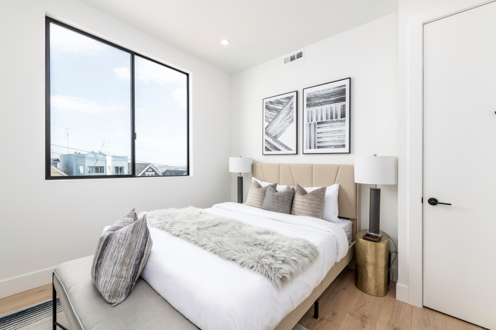 Mid-sized minimalist guest light wood floor bedroom photo in San Francisco with white walls