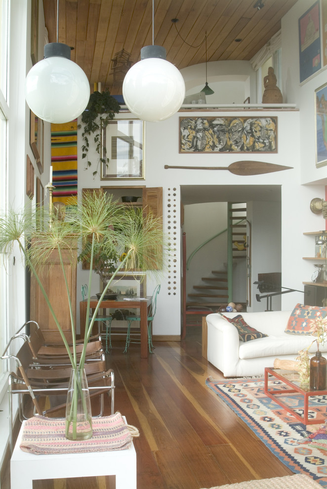 This is an example of an eclectic living room in Miami with white walls and medium hardwood floors.