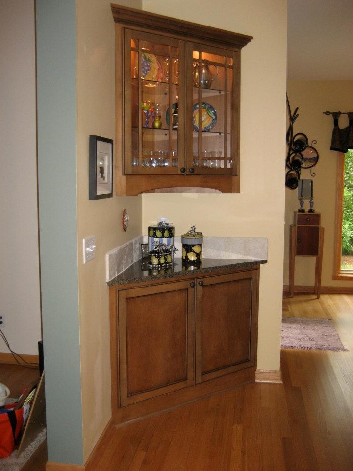 Open concept kitchen - mid-sized transitional l-shaped dark wood floor open concept kitchen idea in Milwaukee with a double-bowl sink, recessed-panel cabinets, dark wood cabinets, beige backsplash, stone tile backsplash, stainless steel appliances, an island and granite countertops