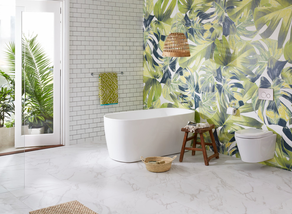 This is an example of a mid-sized tropical master bathroom in Brisbane with a freestanding tub, a wall-mount toilet, marble floors and multi-coloured walls.