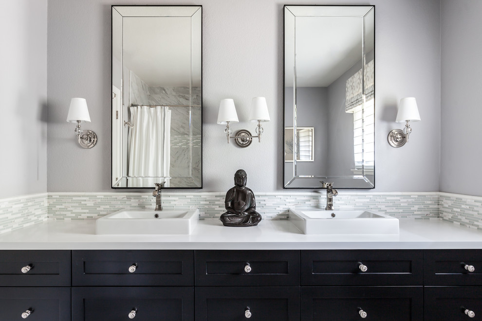 Inspiration for a transitional bathroom in Sacramento with shaker cabinets, black cabinets, a drop-in tub, a shower/bathtub combo, a two-piece toilet, gray tile, matchstick tile, grey walls, marble floors, a vessel sink and engineered quartz benchtops.