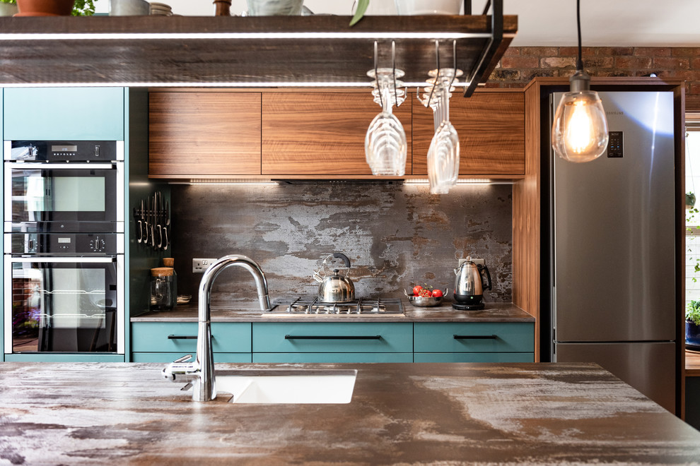 Photo of a mid-sized contemporary galley eat-in kitchen in Other with a drop-in sink, turquoise cabinets, quartzite benchtops, metallic splashback, slate splashback, stainless steel appliances, porcelain floors, white floor and multi-coloured benchtop.