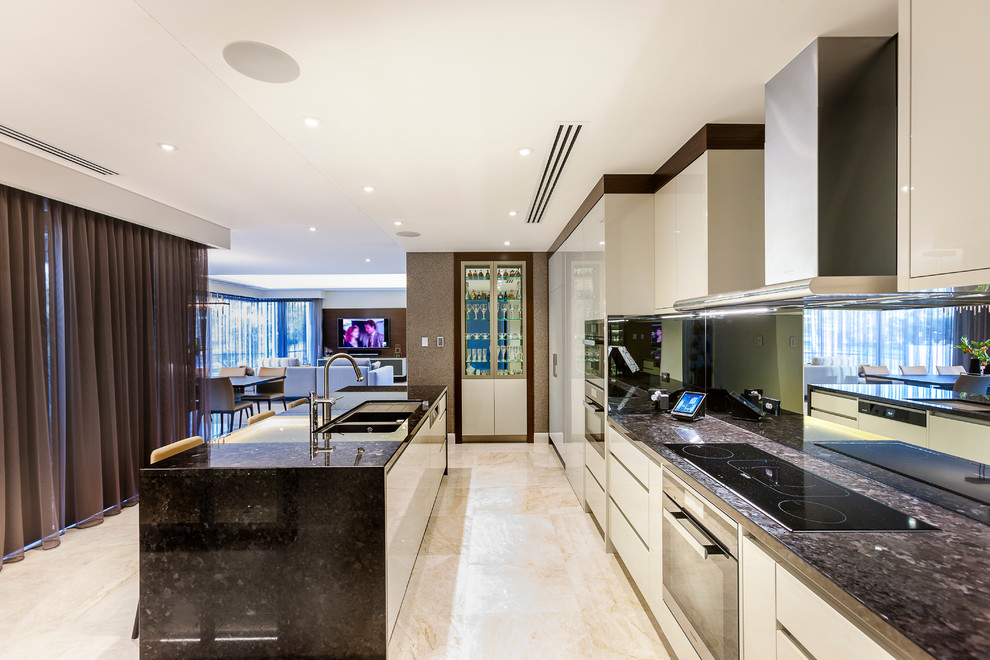 This is an example of a contemporary galley kitchen in Perth with a double-bowl sink, flat-panel cabinets, white cabinets, mirror splashback, stainless steel appliances and with island.
