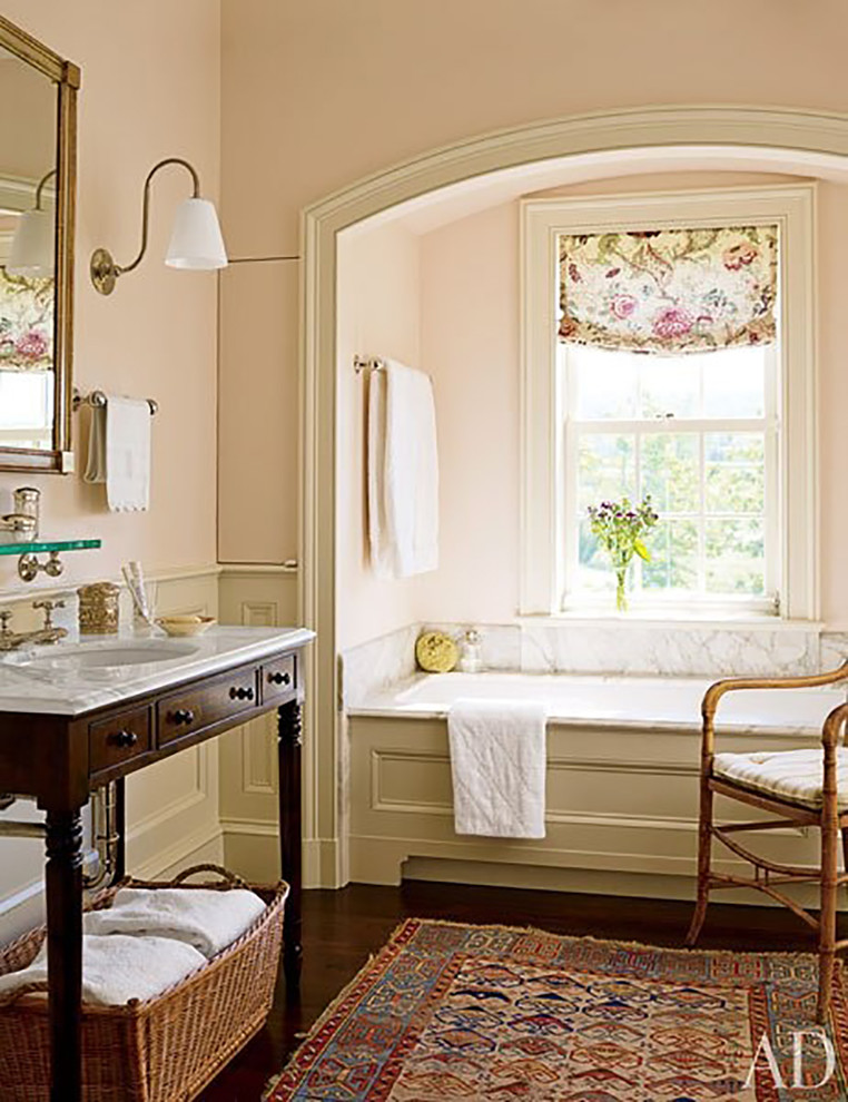 Design ideas for a mid-sized country bathroom in San Diego with a console sink, a drop-in tub, furniture-like cabinets, dark wood cabinets, marble benchtops, white tile, stone tile, beige walls and dark hardwood floors.