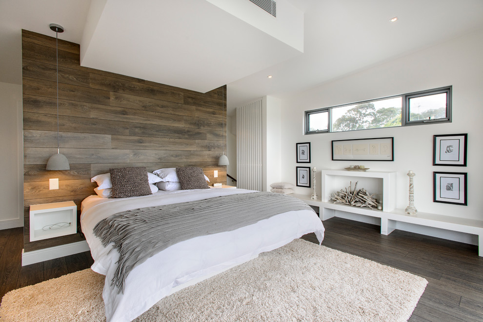 Contemporary bedroom in Sydney with white walls and dark hardwood floors.