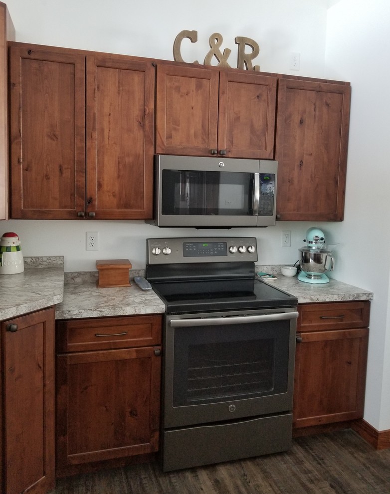 Inspiration for a transitional u-shaped kitchen remodel with an undermount sink, shaker cabinets, laminate countertops, stainless steel appliances and an island