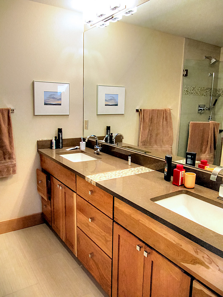 Mid-sized transitional master glass tile and multicolored tile porcelain tile corner shower photo with quartz countertops, shaker cabinets, medium tone wood cabinets, beige walls and an undermount sink