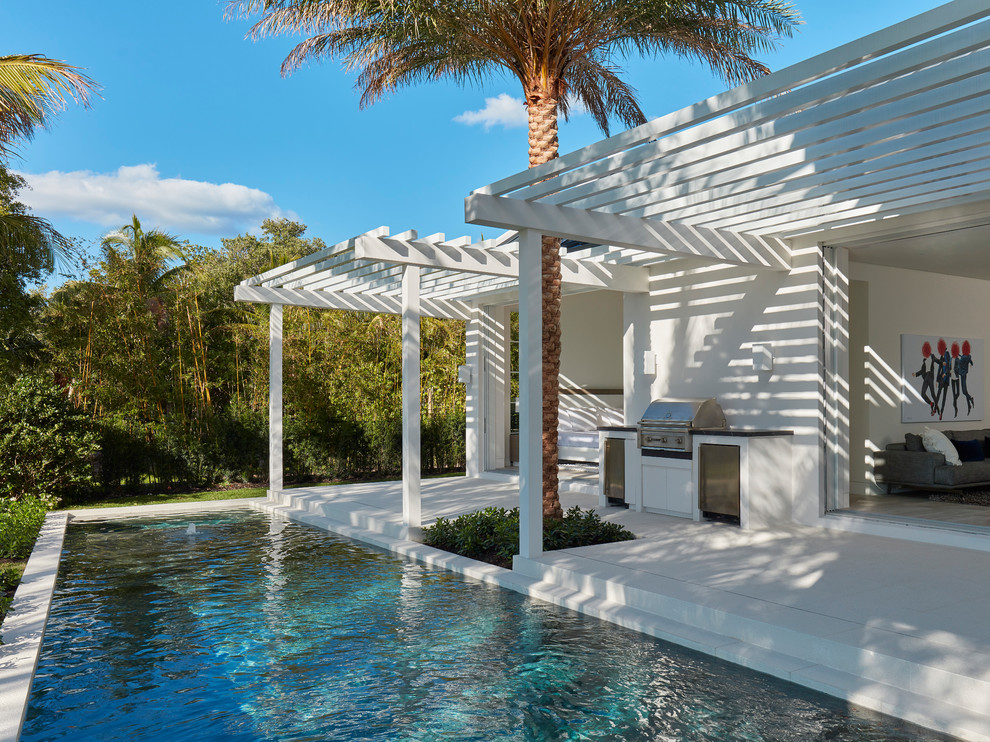 Design ideas for a mid-sized contemporary backyard patio in Miami with an outdoor kitchen, concrete slab and a pergola.