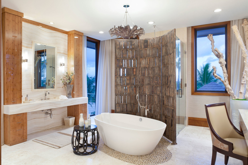 This is an example of a tropical master bathroom in Miami with a freestanding tub.