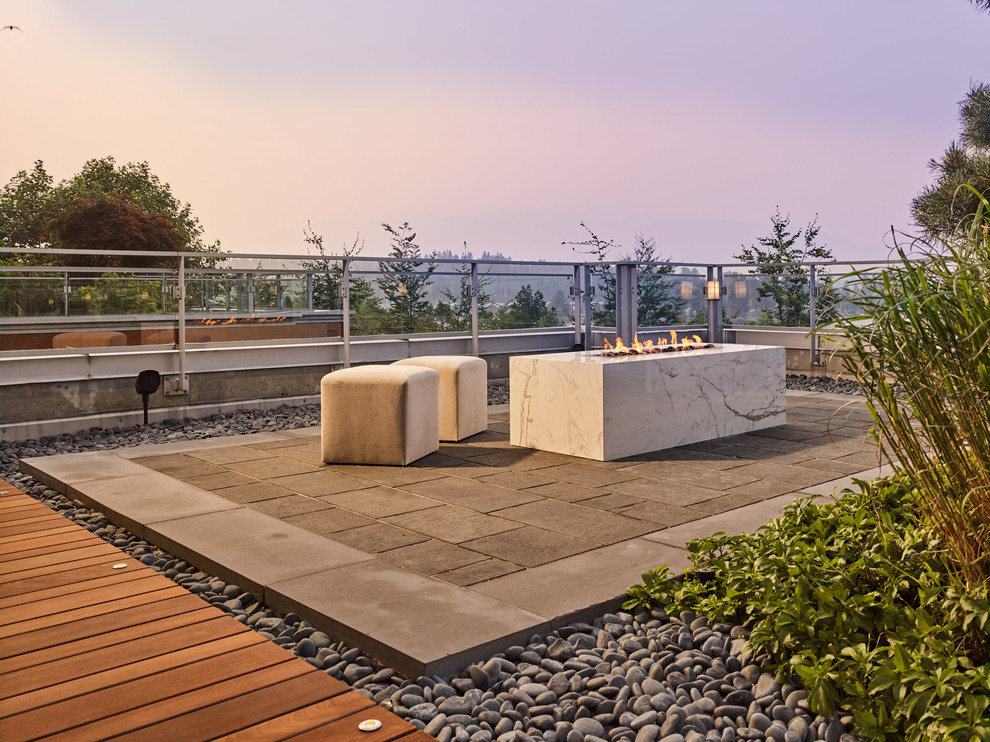 Design ideas for a large contemporary courtyard deck in Vancouver with a fire feature and no cover.
