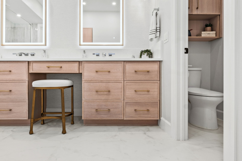 Transitional master gray tile and porcelain tile porcelain tile, white floor and double-sink walk-in shower photo with shaker cabinets, light wood cabinets, a two-piece toilet, white walls, an undermount sink, quartz countertops, white countertops, a niche and a built-in vanity