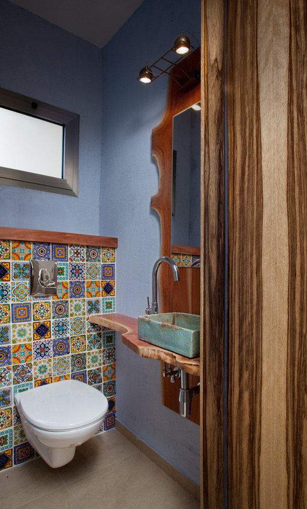 Photo of a contemporary powder room in Other with a vessel sink and a wall-mount toilet.
