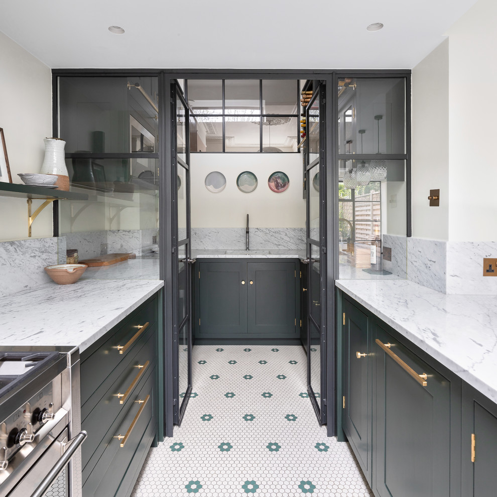 Photo of a mid-sized contemporary u-shaped eat-in kitchen in London with an integrated sink, shaker cabinets, green cabinets, marble benchtops, white splashback, marble splashback, stainless steel appliances, porcelain floors, with island, grey floor and white benchtop.