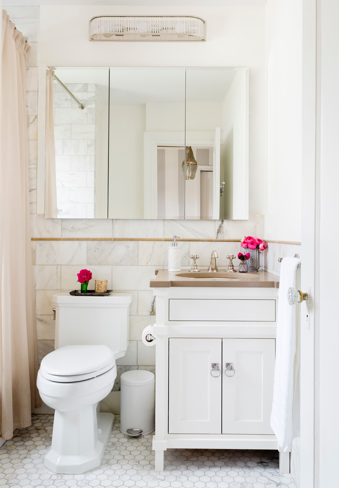 Design ideas for a mid-sized traditional bathroom in New York with shaker cabinets, white cabinets, an alcove tub, a shower/bathtub combo, brown tile, gray tile, white tile, stone tile, white walls, marble floors and an undermount sink.