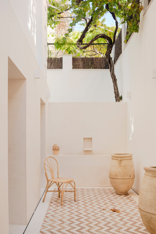 Idee per un patio o portico mediterraneo dietro casa con fontane e pavimentazioni in pietra naturale