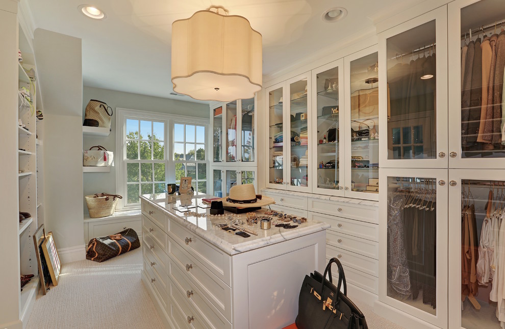 Expansive traditional women's walk-in wardrobe in Chicago with white cabinets, carpet, glass-front cabinets and beige floor.