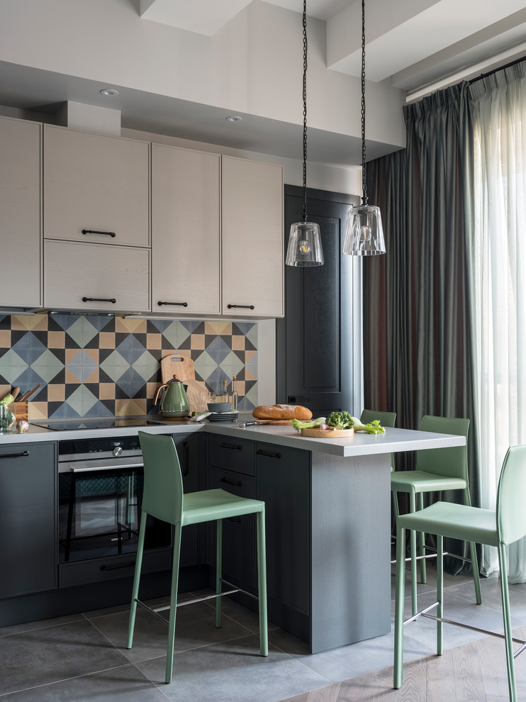 Inspiration for an u-shaped open plan kitchen in Other with raised-panel cabinets, grey cabinets, solid surface benchtops, multi-coloured splashback, ceramic splashback, black appliances, a peninsula and white benchtop.