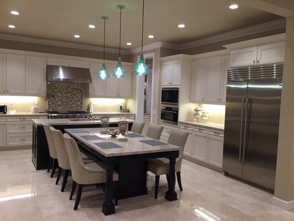 Inspiration for a large contemporary l-shaped open plan kitchen in Orange County with an undermount sink, recessed-panel cabinets, white cabinets, marble benchtops, porcelain splashback, stainless steel appliances, marble floors, white floor, white benchtop and multiple islands.