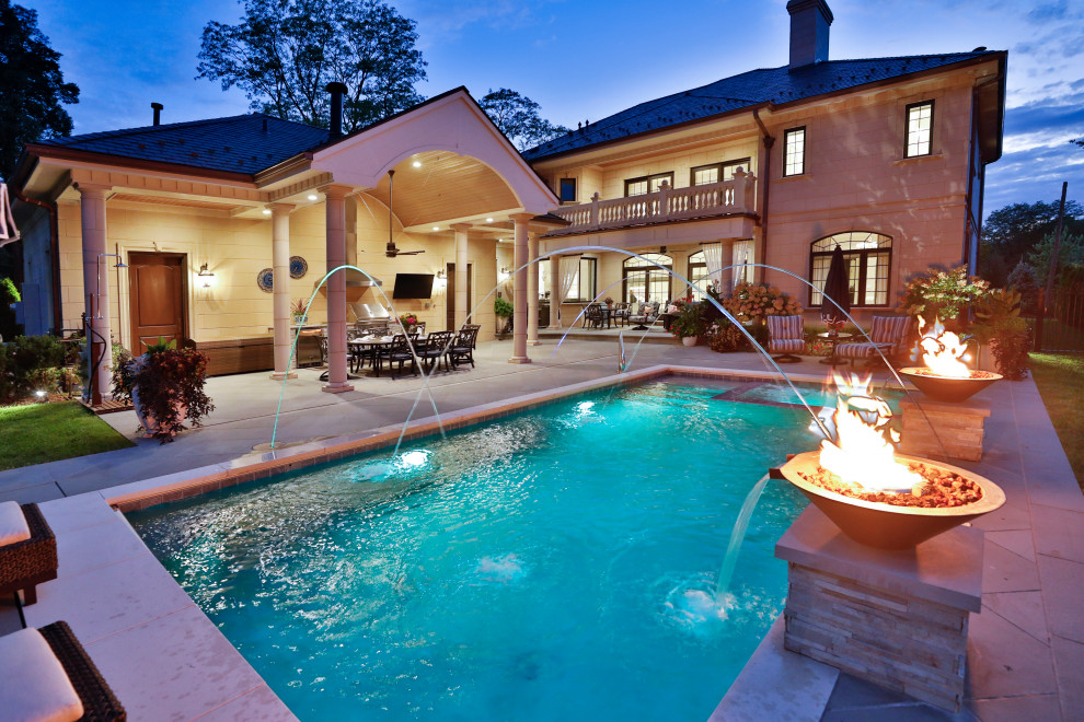 Esempio di una piscina monocorsia classica rettangolare di medie dimensioni e dietro casa con pavimentazioni in pietra naturale
