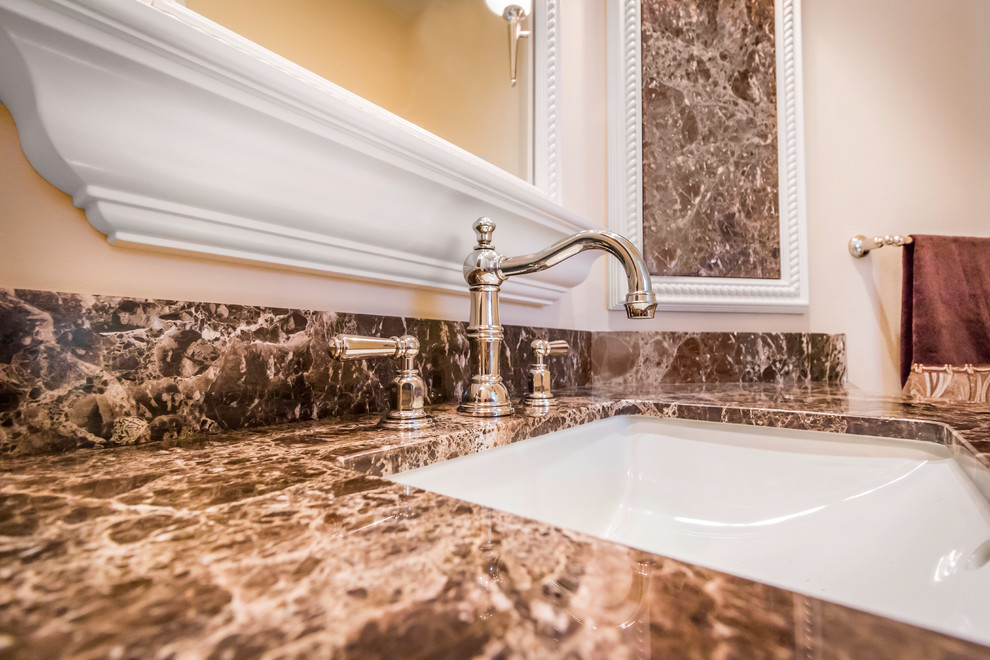 Powder room - small transitional marble floor powder room idea in Miami with an undermount sink, granite countertops and a two-piece toilet
