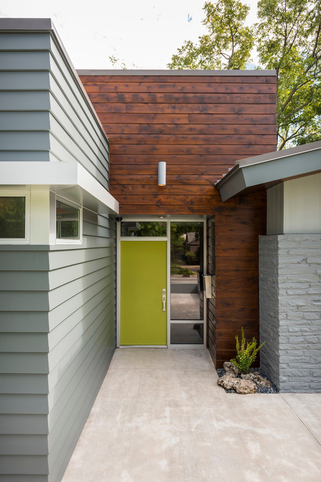 This is an example of a mid-sized contemporary front door in Other with grey walls, concrete floors, a single front door and a green front door.