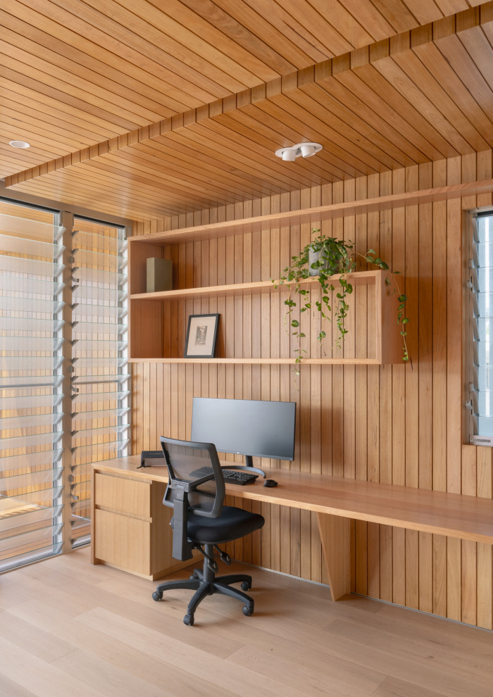 Mid-sized contemporary study room in Sunshine Coast with light hardwood floors, a built-in desk, wood and wood walls.