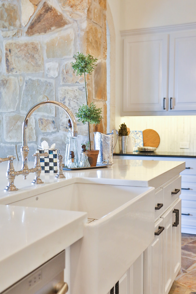 Design ideas for a large traditional u-shaped eat-in kitchen in Austin with a farmhouse sink, raised-panel cabinets, white cabinets, glass benchtops, white splashback, marble splashback, stainless steel appliances, limestone floors, with island, brown floor and yellow benchtop.