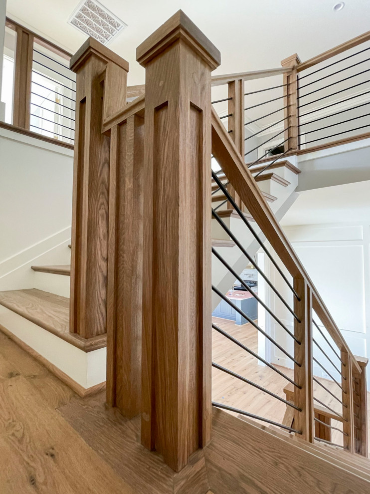 Cette image montre un grand escalier flottant vintage avec des marches en bois, des contremarches en bois et un garde-corps en matériaux mixtes.