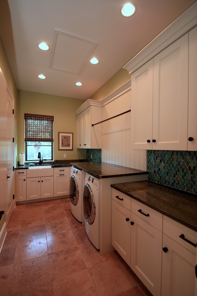 This is an example of an expansive mediterranean u-shaped dedicated laundry room in Tampa with a farmhouse sink, white cabinets, granite benchtops, green walls, terra-cotta floors, a side-by-side washer and dryer, recessed-panel cabinets and brown floor.
