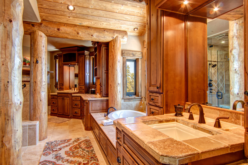 Drop-in bathtub - large rustic master beige tile and limestone tile limestone floor and multicolored floor drop-in bathtub idea with louvered cabinets, dark wood cabinets, red walls and an undermount sink