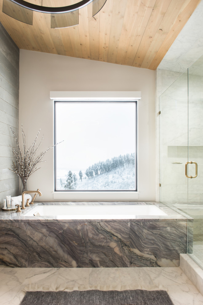 Cette image montre une grande salle de bain principale design avec des portes de placard grises, une baignoire encastrée, un carrelage gris, des carreaux de céramique, un mur beige, un sol en carrelage de céramique, un plan de toilette en marbre, un sol blanc, une cabine de douche à porte battante, un plan de toilette gris, un banc de douche et un plafond en bois.