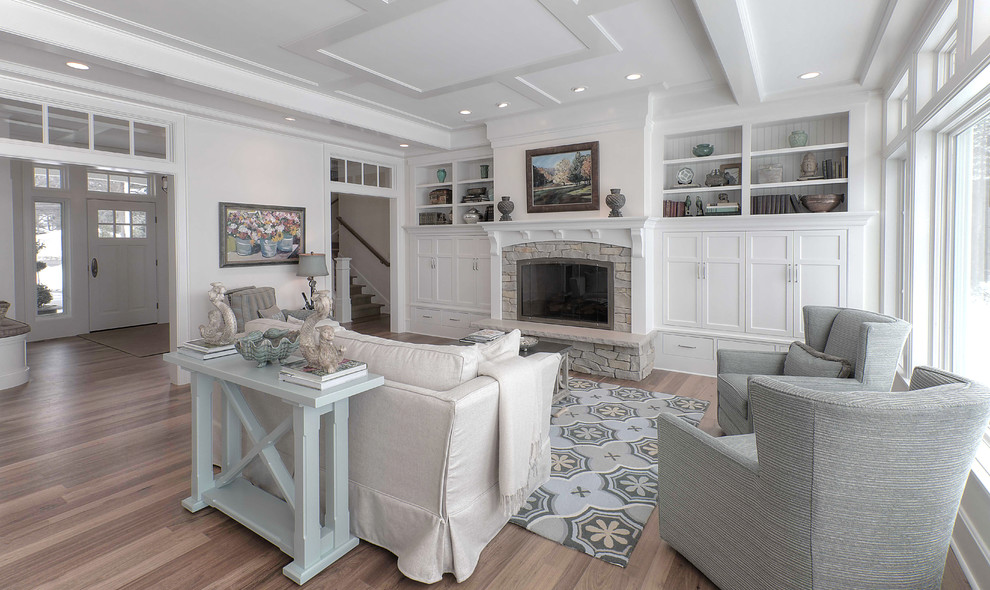 Photo of a mid-sized beach style formal enclosed living room in Other with white walls, medium hardwood floors, a standard fireplace, a stone fireplace surround and no tv.