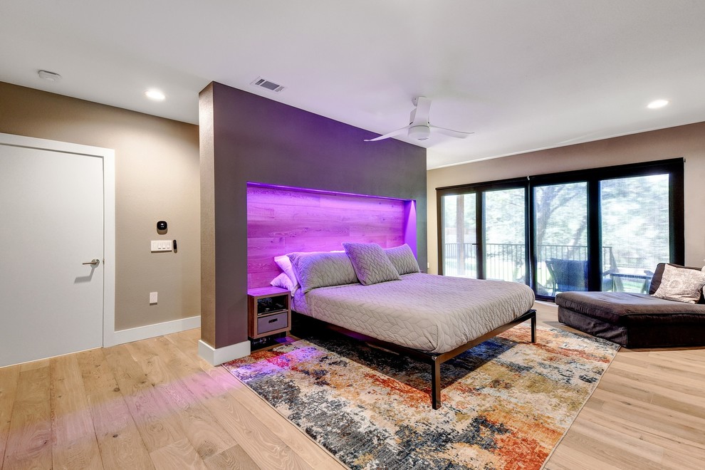 Photo of a large modern master bedroom in Austin with grey walls, light hardwood floors and beige floor.