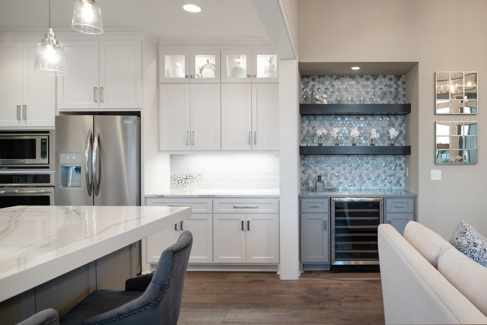 Inspiration for a small arts and crafts galley wet bar in Kansas City with no sink, flat-panel cabinets, grey cabinets, granite benchtops, multi-coloured splashback, mosaic tile splashback, medium hardwood floors, brown floor and grey benchtop.