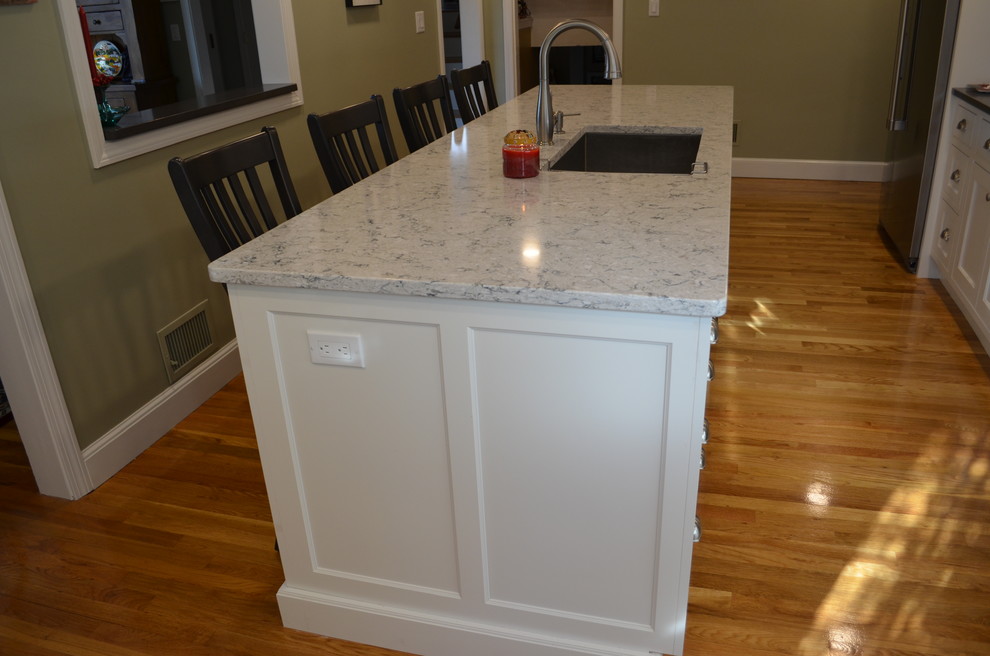 Eat-in kitchen - transitional l-shaped light wood floor eat-in kitchen idea in Boston with an undermount sink, beaded inset cabinets, white cabinets, quartz countertops, white backsplash, ceramic backsplash, stainless steel appliances, an island and gray countertops